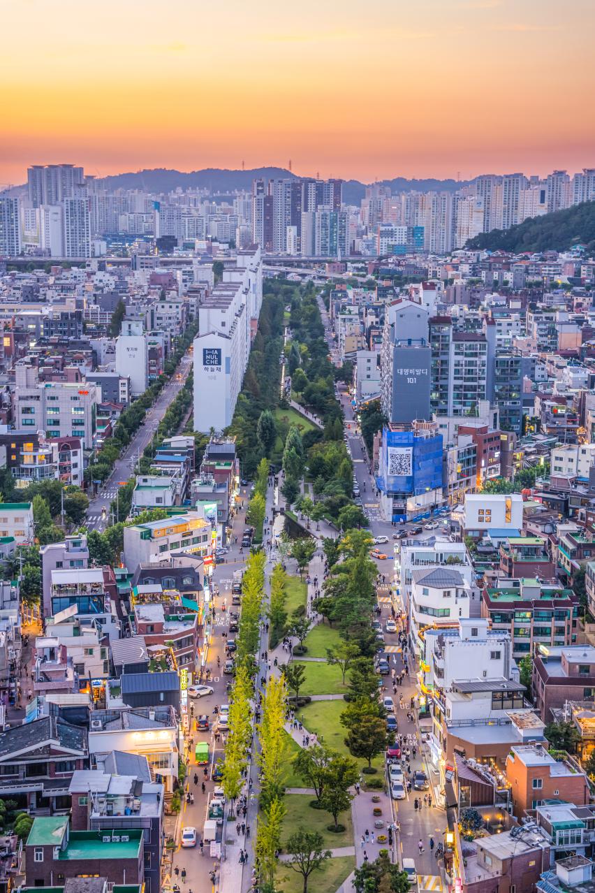 노을 아래 연남동 경의선숲길과 주변 시가지의 드론 풍경
